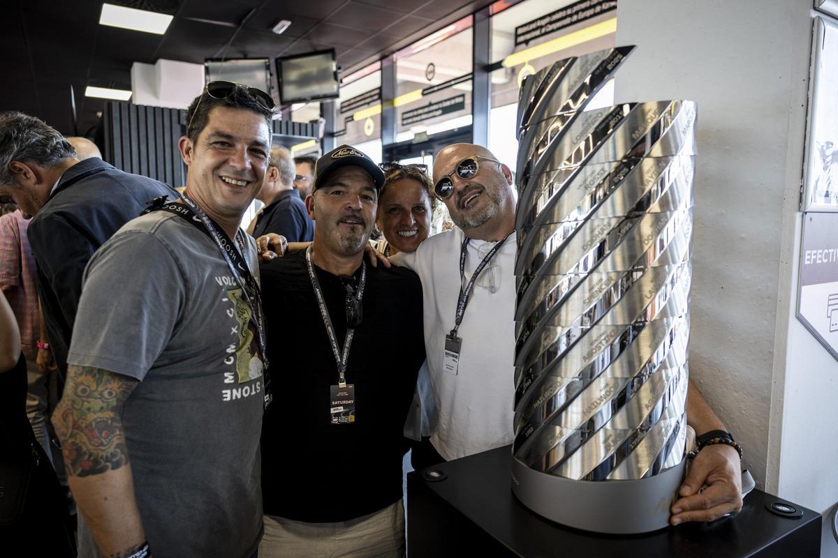 Un grupo de aficionados se fotografía con el trofeo del Campeonato Mundial de Pilotos oficial de MotoGP.