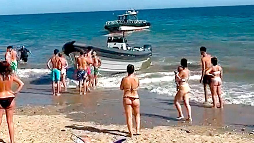 Persecución de película a una narcolancha en la playa de La Antilla abarrotada de gente