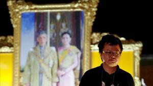 Anon Nampa, uno de los líderes de las protestas antigubernamentales, posa ante una foto de los reyes de Tailandia.