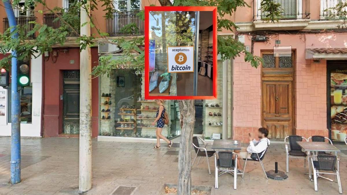 El cartel anunciado los pagos aceptados en Bitcoin destacado sobre la fachada de la zapatería alicantina