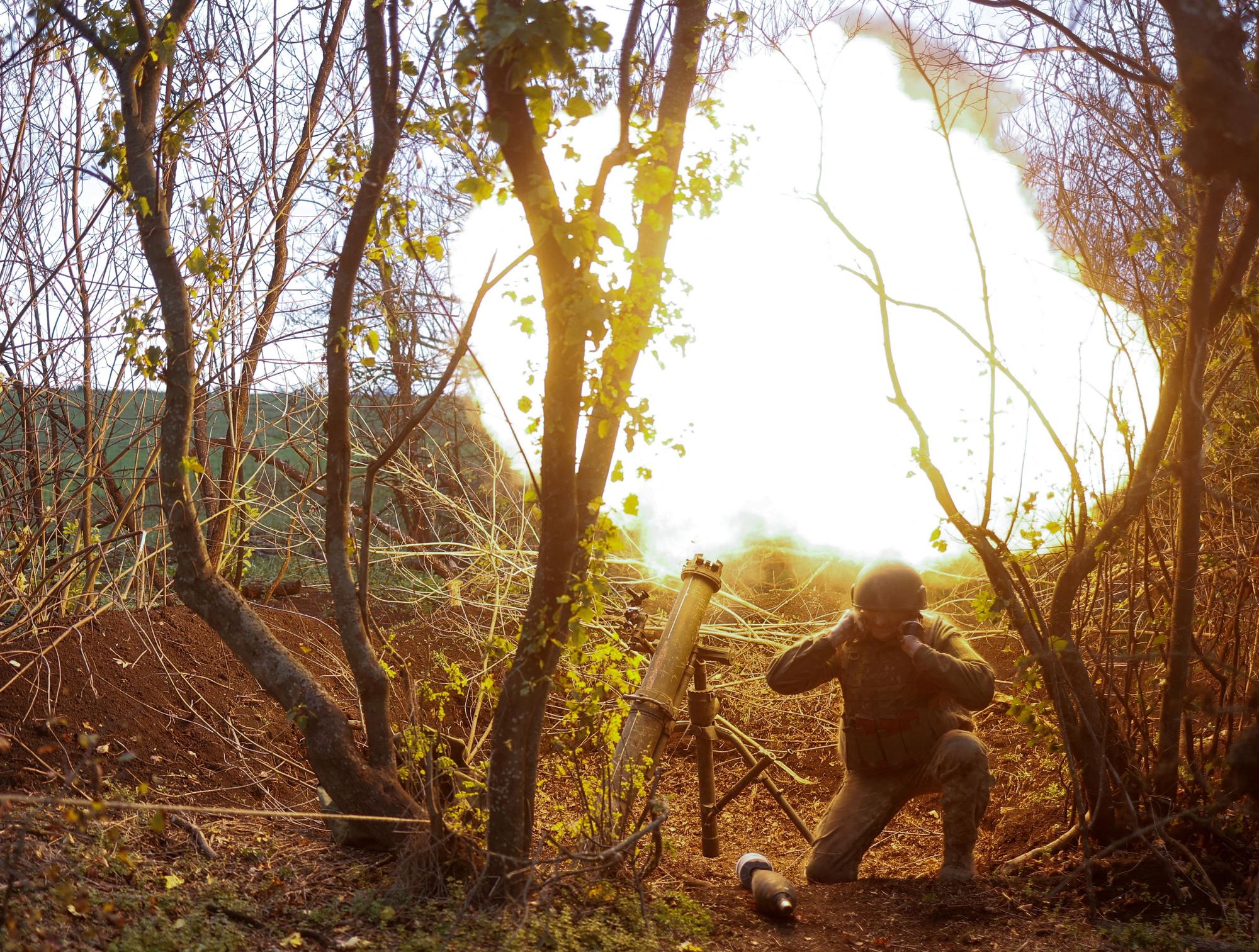 Ukrainian serviceman fires with a mortar toward Russian positions in a frontline in Mykolaiv region