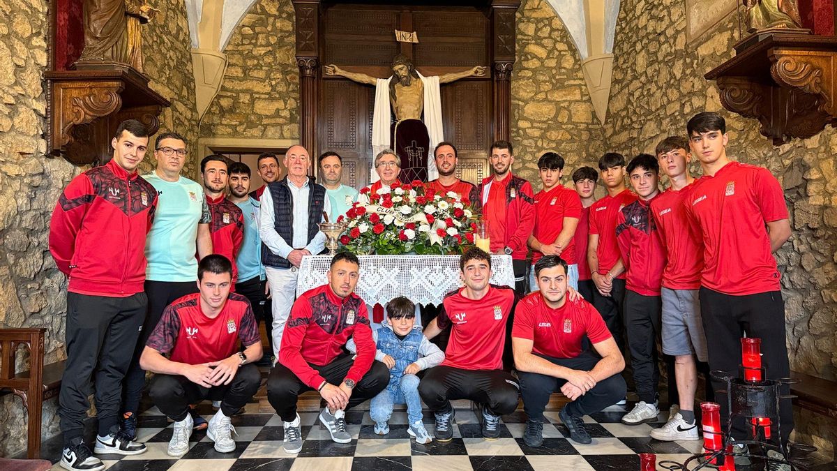 El equipo del Siero, junto al párroco Fermín Riaño, en el centro, y su ofrenda floral en la capilla de Santa Ana