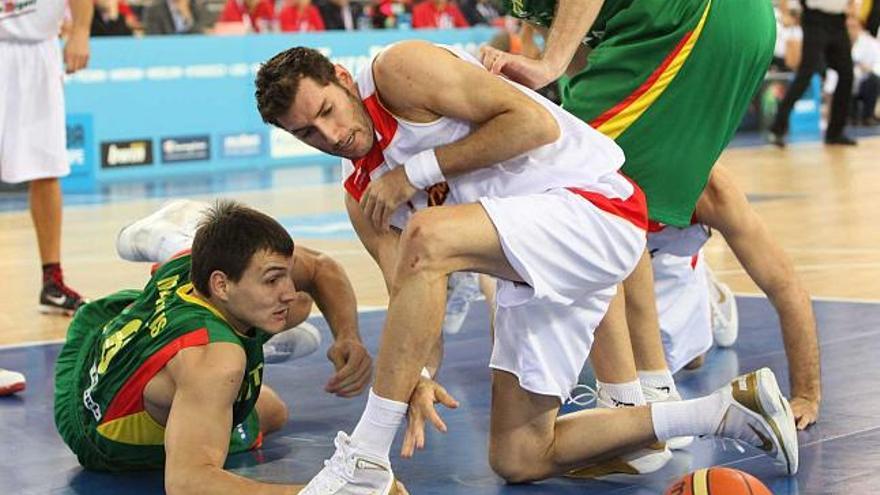 Rudy Fernández lucha un balón con dos jugadores lituanos. / michalowski