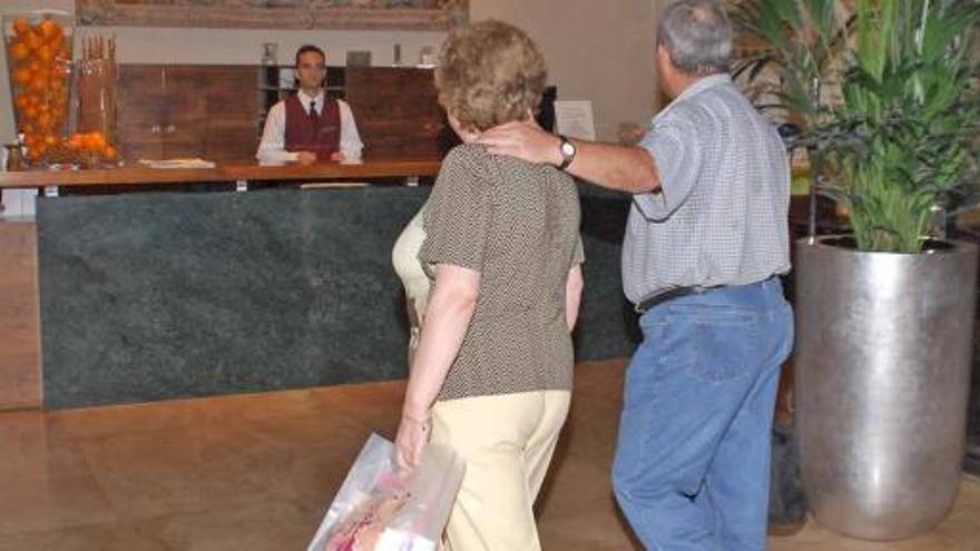 Un matrimonio llega a la recepción de un hotel.