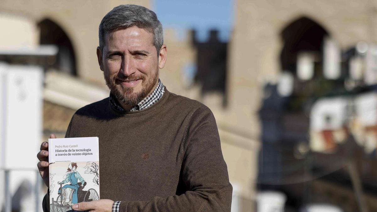 Pedro Ruiz-Castell sosté a les mans un exemplar de la seua publicació ‘Històries de la tecnologia a través de 20 objectes’