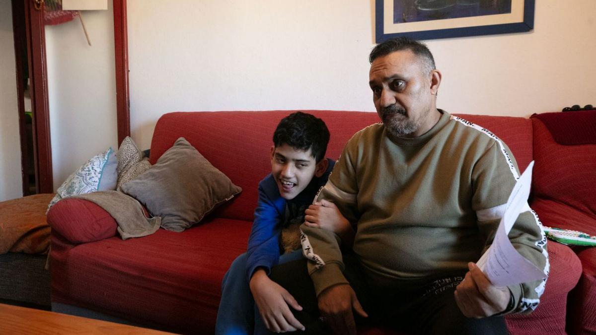 Mohammad se agarra del brazo de su padre, mientras este explica su caso.
