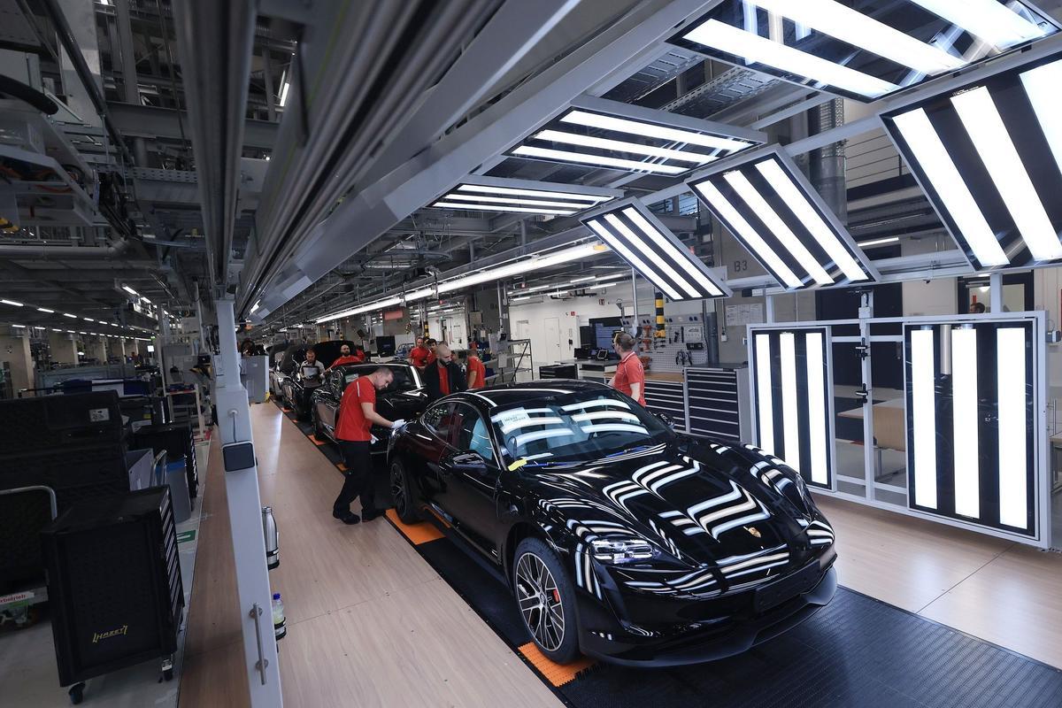 Los empleados trabajan en las carrocerías de los automóviles de lujo Porsche Taycan totalmente eléctricos en la línea de producción de la fábrica de Porsche AG en Stuttgart, Alemania.