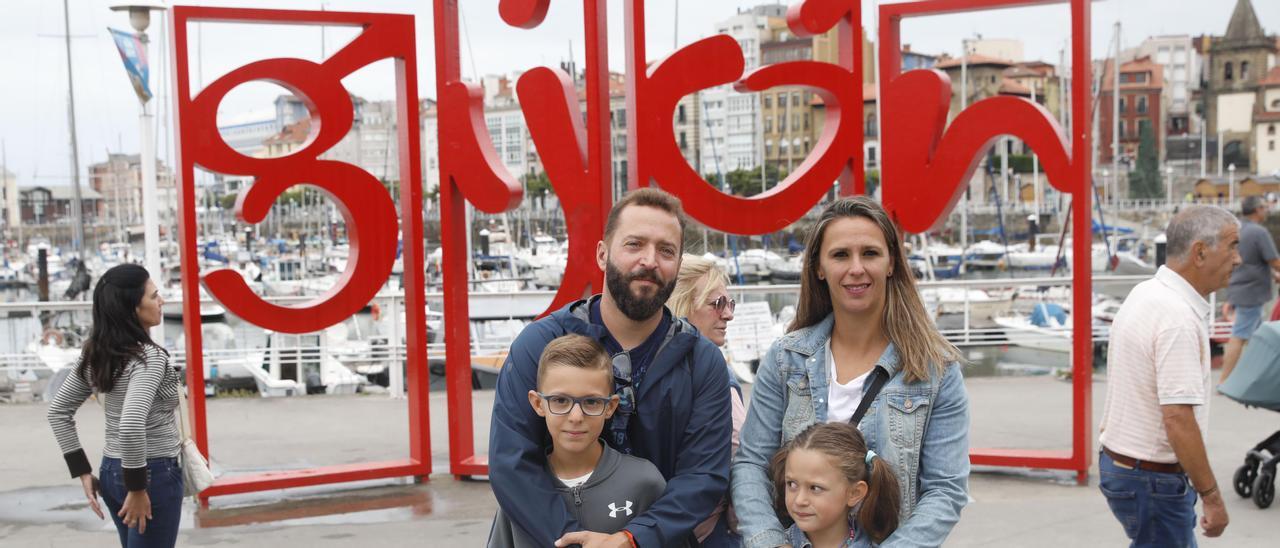 Juanjo Valero y Cristina Escobar, con sus hijos Ángel y Aitana, ante las letronas de Gijón.