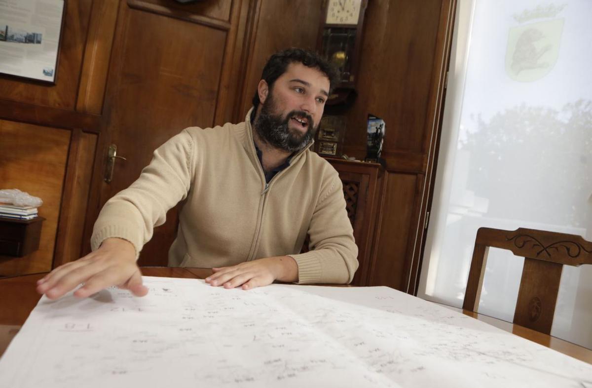 Pedro Rodríguez y Gregorio Fernández, jubilados de la pesca y del comercio, respectivamente, en el puerto de Luarca; al fondo, el barrio del Cambaral, de donde es el primero. | Fernando Rodríguez