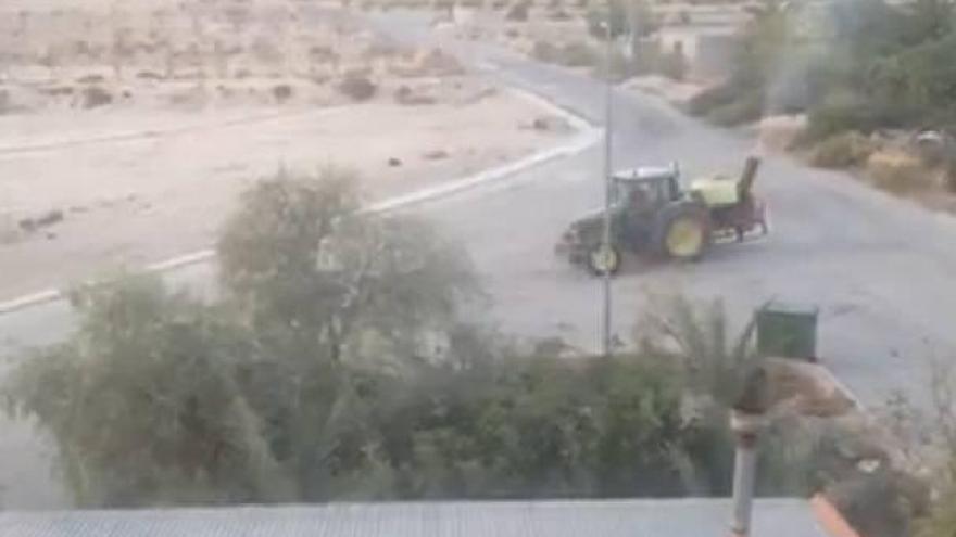 Un tractor vierte ambientador en Orihuela para tapar los malos olores del vertedero