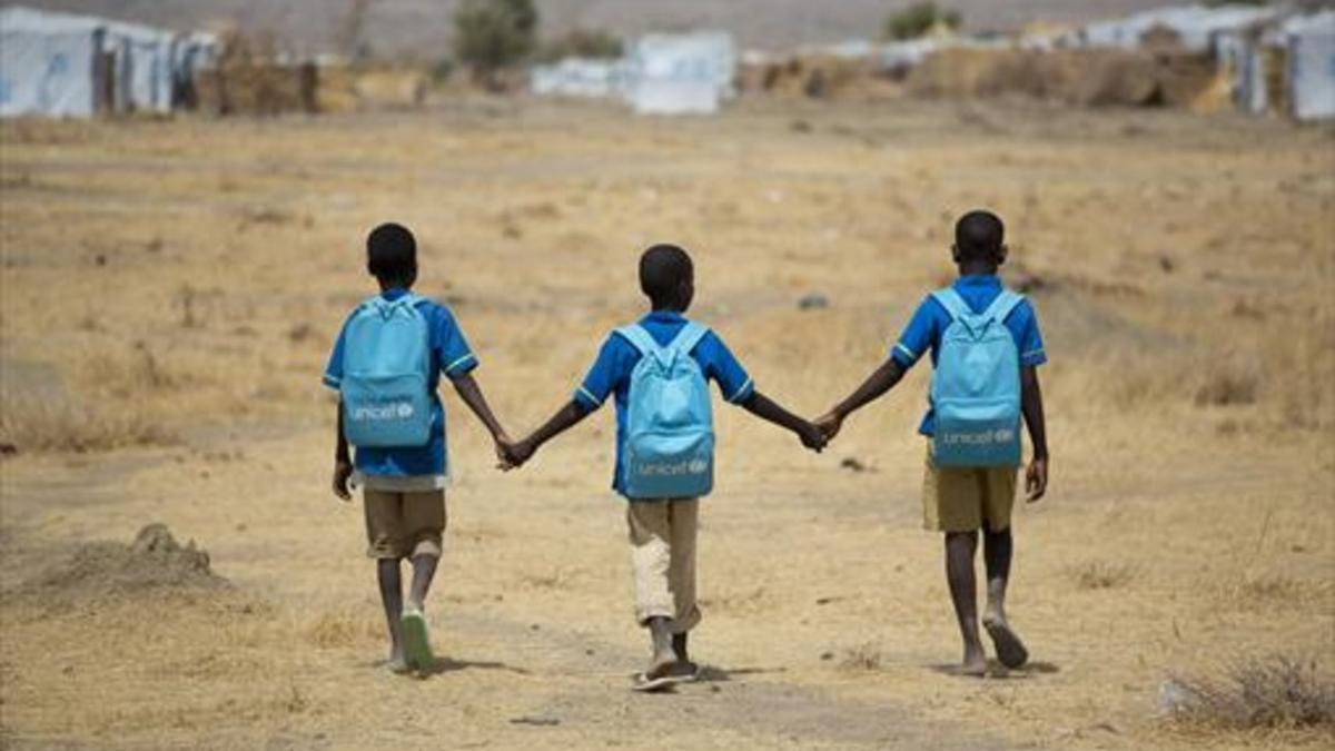 NORTE DE ANGOLA. Niños refugiados, junto a un viejo autocar en Dundu.