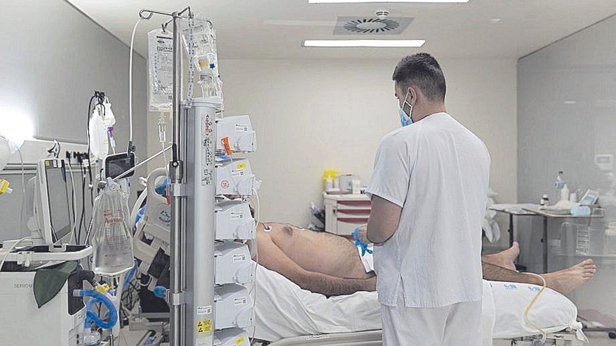 Un sanitario atiende a un paciente Covid.