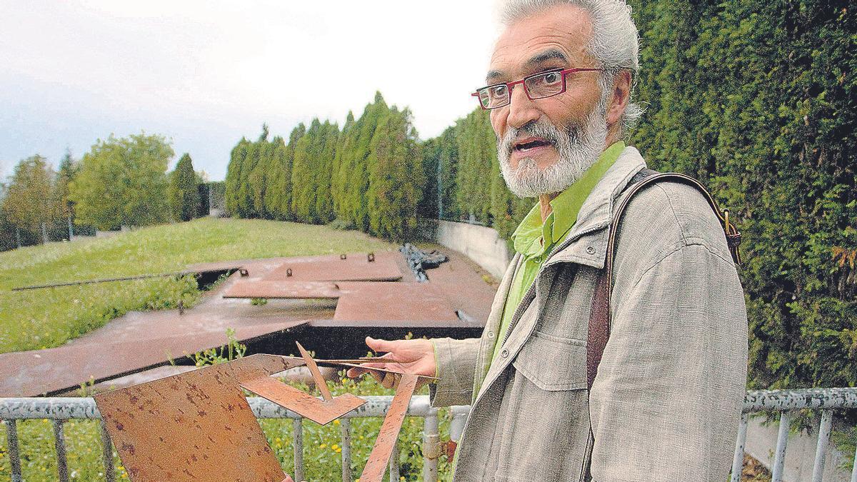 El escultor Fernando Alba sostiene entre sus manos una réplica a pequeña escala de su obra, ante las placas originales desmontadas y amontonadas en la parcela municipal del Parque de Invierno.