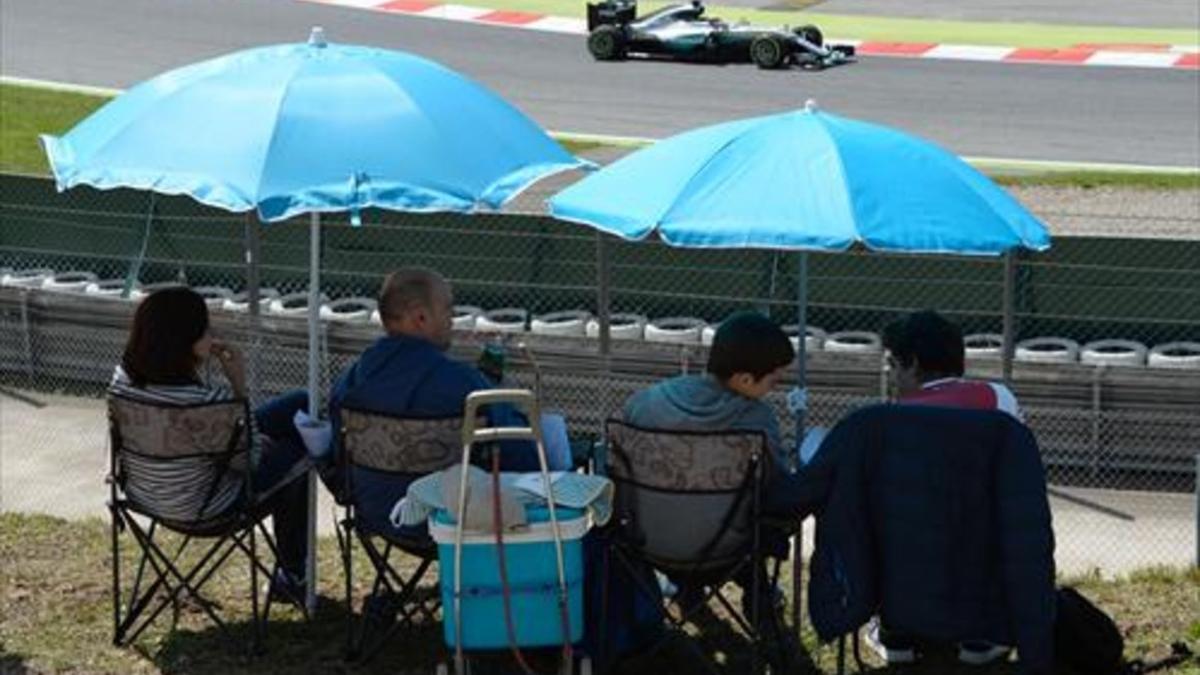 Una familia sigue la competición clasificatoria, ayer, en el circuito de Montmeló.