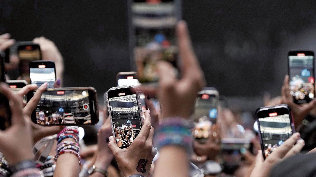 Espectadores de un concierto grabando la actuación con sus teléfonos móviles