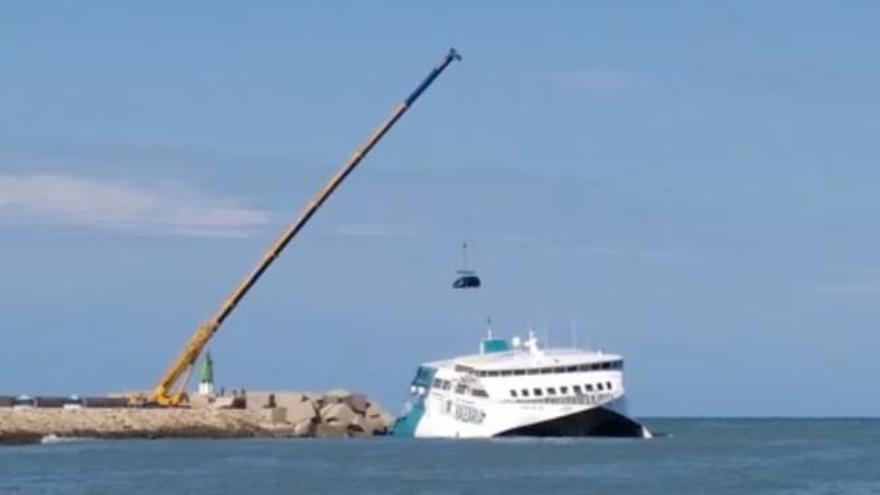 Así retiran con una grúa los coches del ferry encallado en Dénia