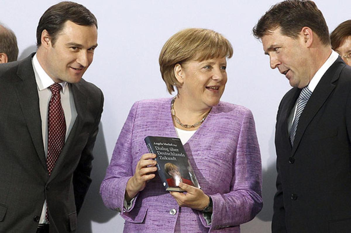 La cancellera alemanya, Angela Merkel, presenta el llibre ’Diàleg sobre el futur d’Alemanya’ a la Cancelleria de Berlín, juntament amb l’editor Sven Murmann (esquerra) i l’autor, Christoph Schelegel (dreta).