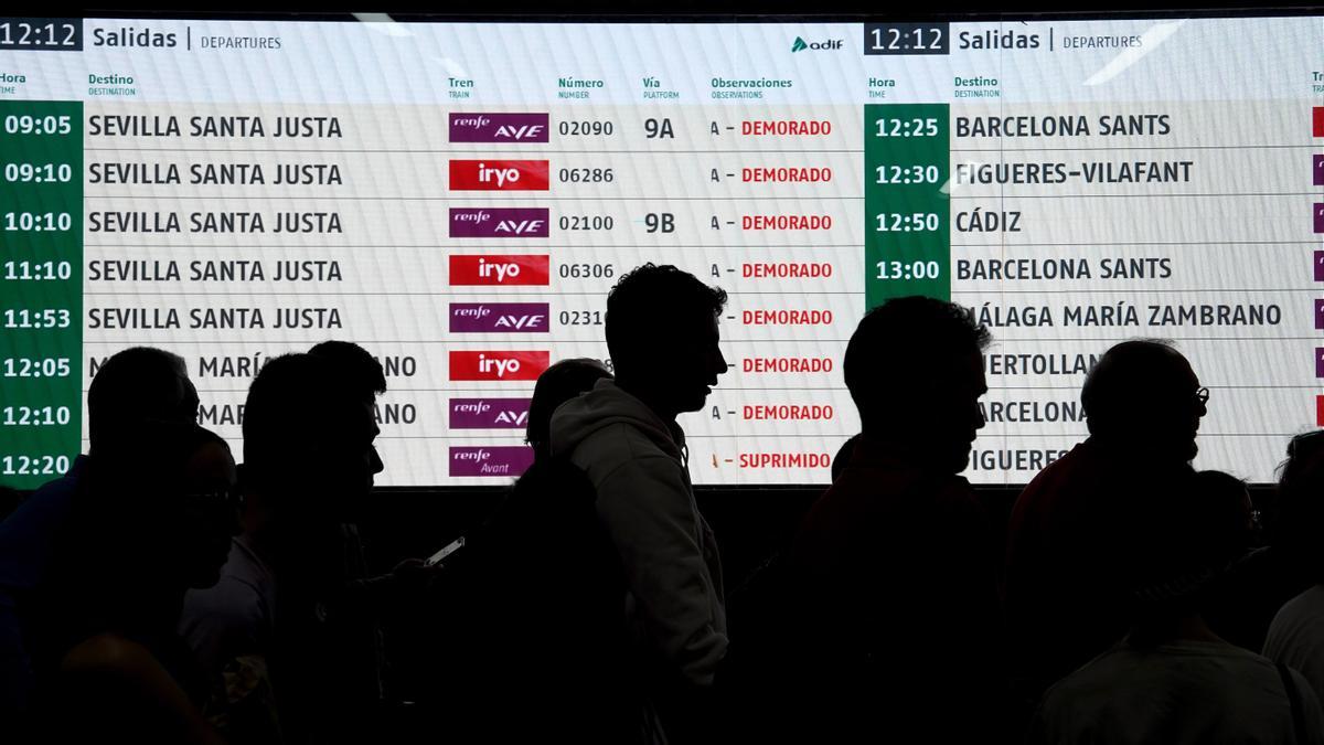 Viajeros esperan poder tomar el tren retrasado en la estación de Atocha