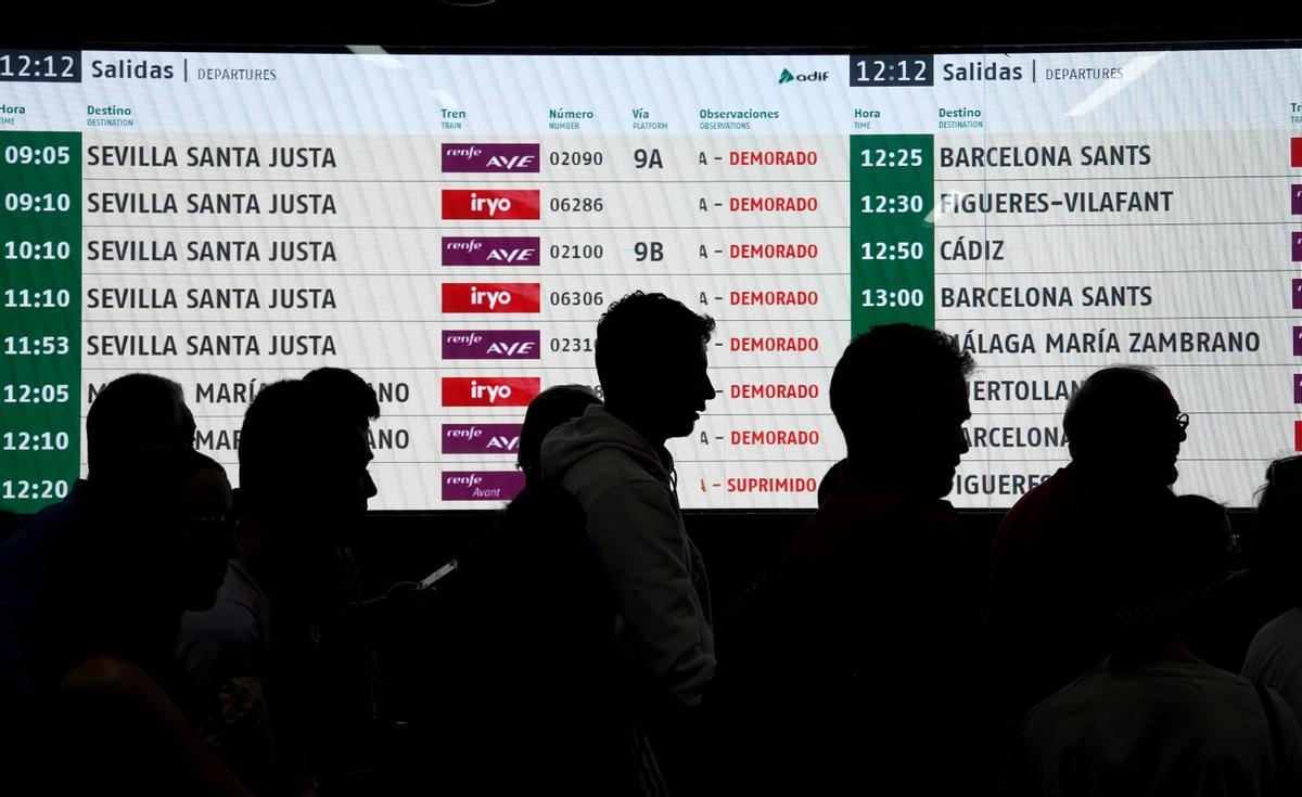 Viajeros esperan poder tomar el tren retrasado en la estación de Atocha