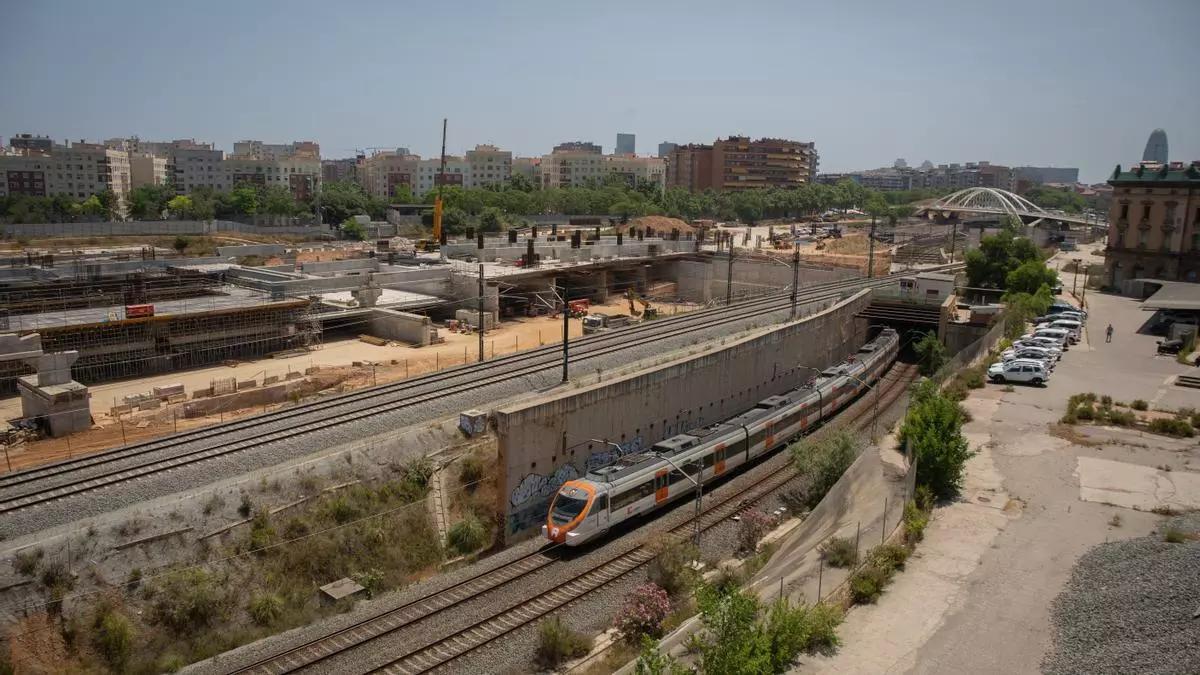 L’estació en obres, a l’esquerra, i un tren de Rodalies passant pel costat de la terminal (arxiu)