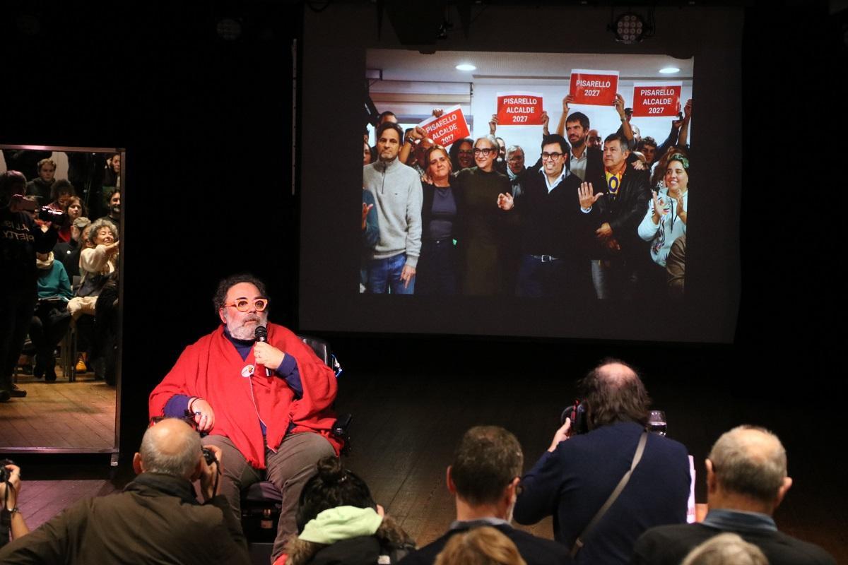 Bob Pop, mostrando en el acto una foto de los dirigentes de los Comuns dando apoyo a Pisarello