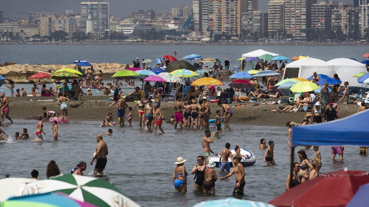 Numerosas personas llenan la playa del Palo de Málaga este domingo.