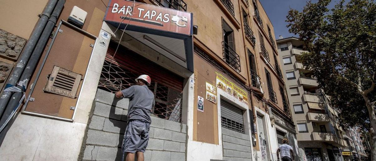Ein Arbeiter verrammelt ein leerstehendes Wohnobjekt in Palma de Mallorca, um es vor Hausbesetzern zu schützen
