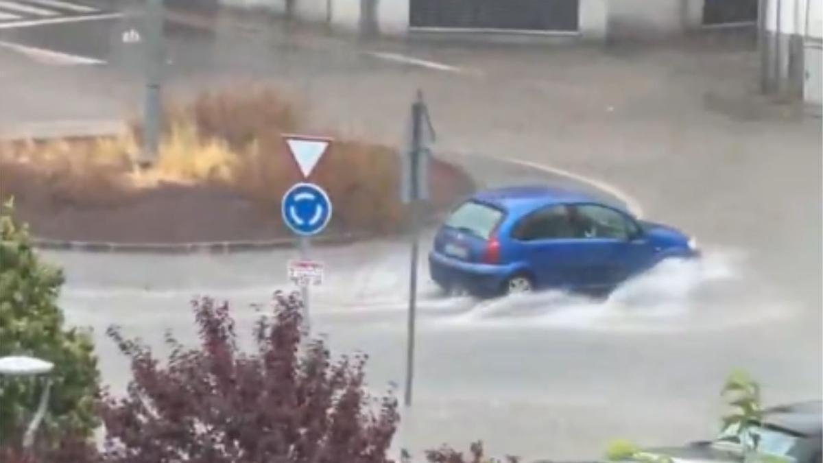 Un coche circulando por una rotonda inundada por las lluvias, en Sallent.
