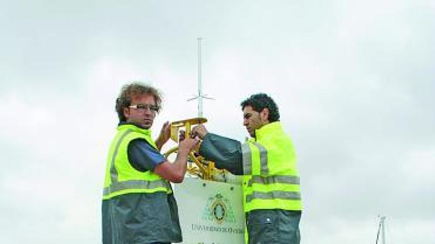 Dos técnicos, antes de lanzar la boya oceanográfica a Peñas.