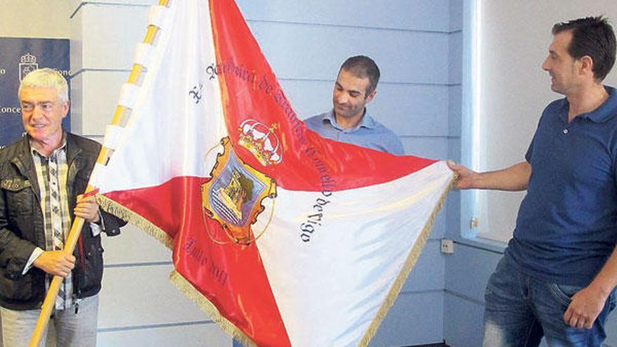 Manel Fernández, Anselmo Miranda y Darío Méndez sostienen la bandera de la regata. // Felipe Carnotto