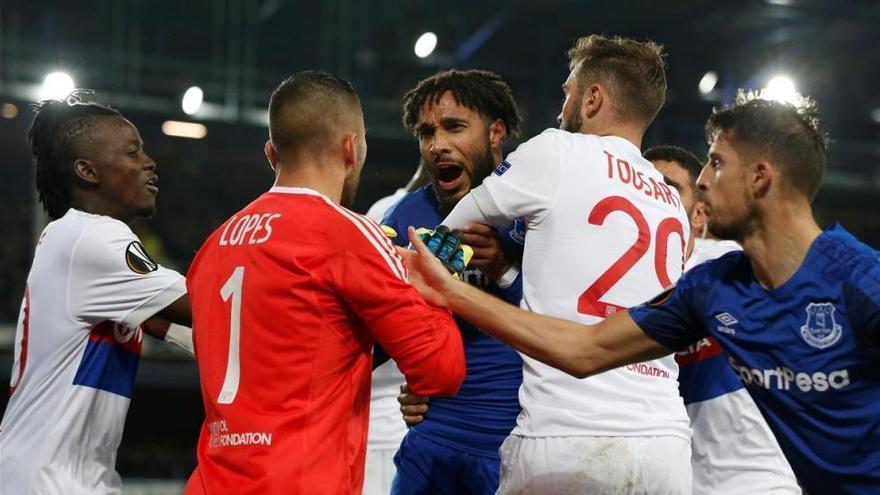 Un hincha del Everton se enfrenta a los jugadores del Lyón con un niño en brazos