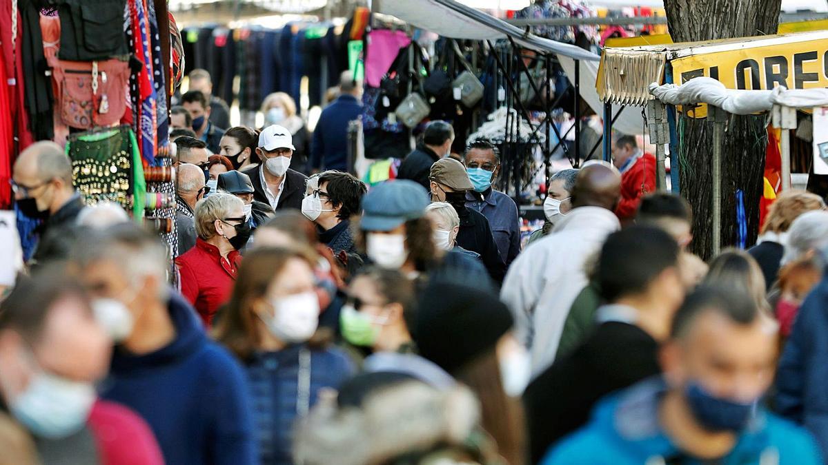 Cientos de personas se agolpan frente a los puestos del mercadillo de Navidad junto al Mercado Central de València. | EFE/JUAN CARLOS CÁRDENAS