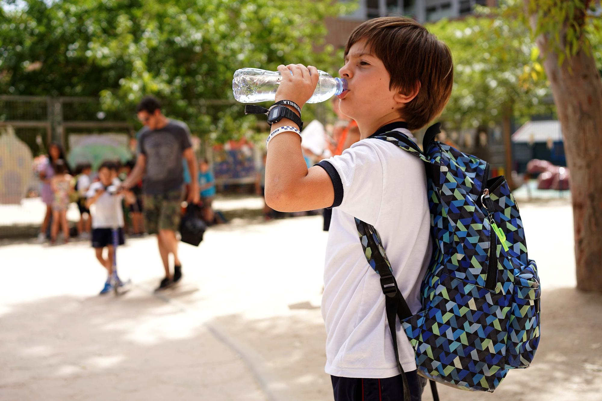 Un niño bebe agua en plena ola de calor en Madrid