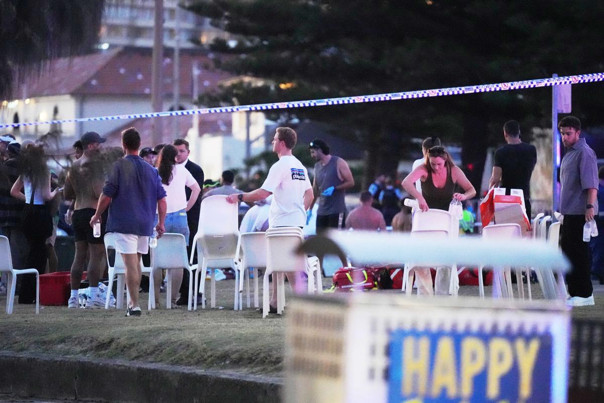 People and emergency workers gather at location where a holiday event was taking place and then a reported shooting at Bondi Beach in Sydney, Sunday, Dec. 14, 2025. (AP Photo/Mark Baker) Associate Press/ LaPresse Only Italy and Spain. EDITORIAL USE ONLY ITALY AND SPAIN