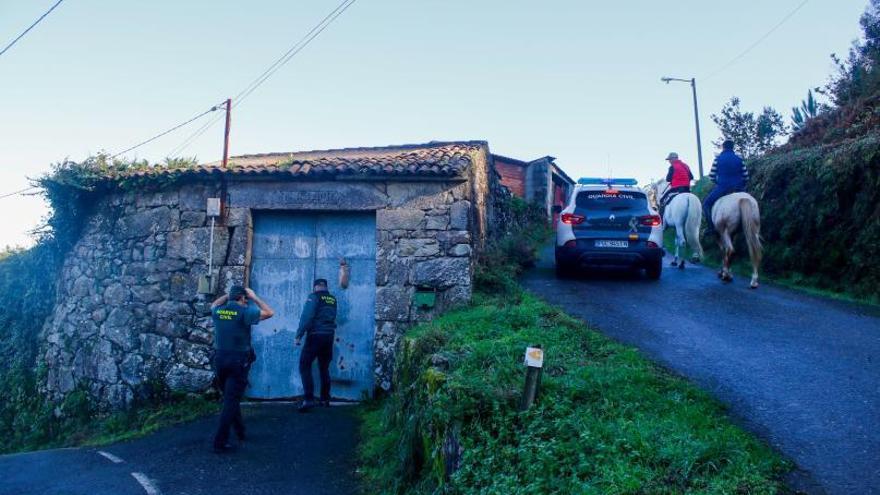 Dos guardias civiles acceden a la vivienda del hombre de Armenteira que sufrió un incendio en su casa el 3 de diciembre. |   // IÑAKI ABELLA