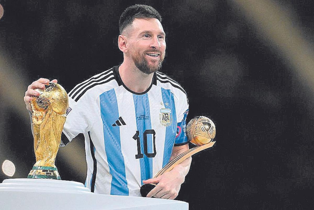 Messi touches the World Cup trophy before receiving it after winning the title in Qatar in December 2022.