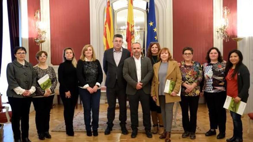 Enric Morera y Carles Peris junto a la delegación de mujeres agricultoras ayer en las Cortes.