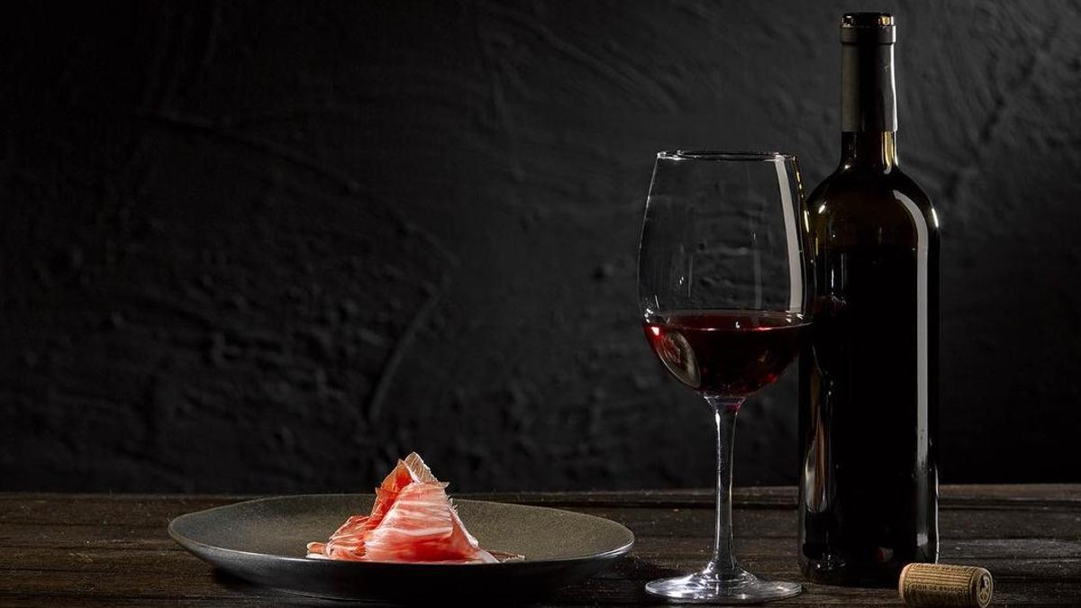 Una finísima loncha de jamón ibérico de bellota con un vino tinto.