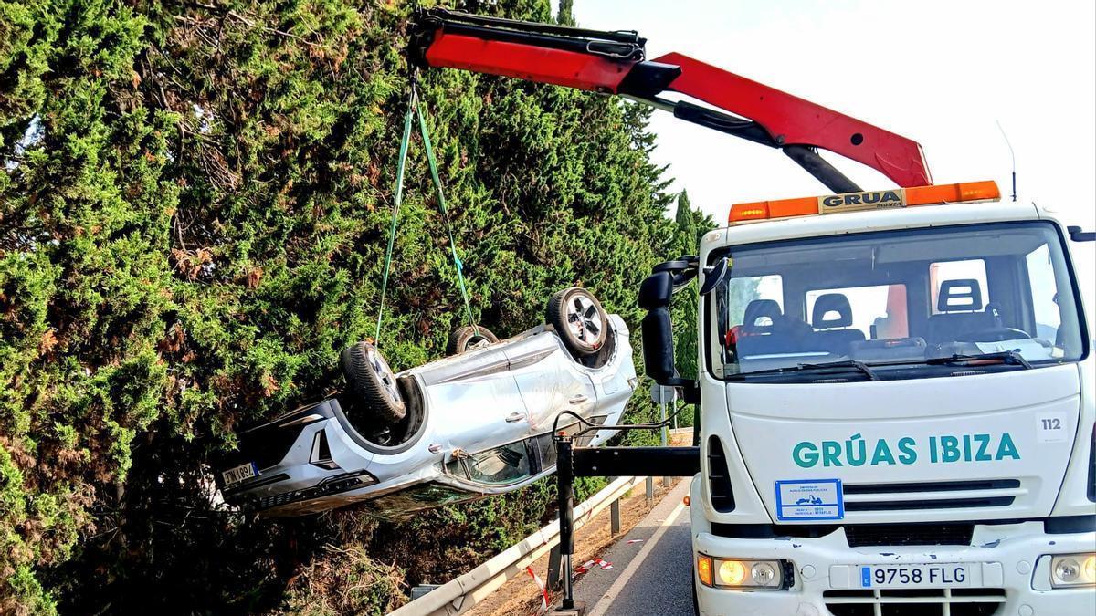 La grúa pluma levantando el coche de la orilla de la carretera