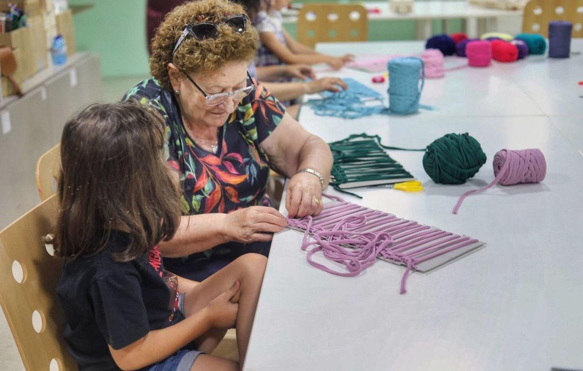 La abuela Manuela ayuda a su nieto Hernán con su labor. | ALBA PRIETO