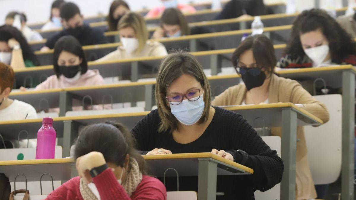 Varias personas realizan un examen de oposiciones.