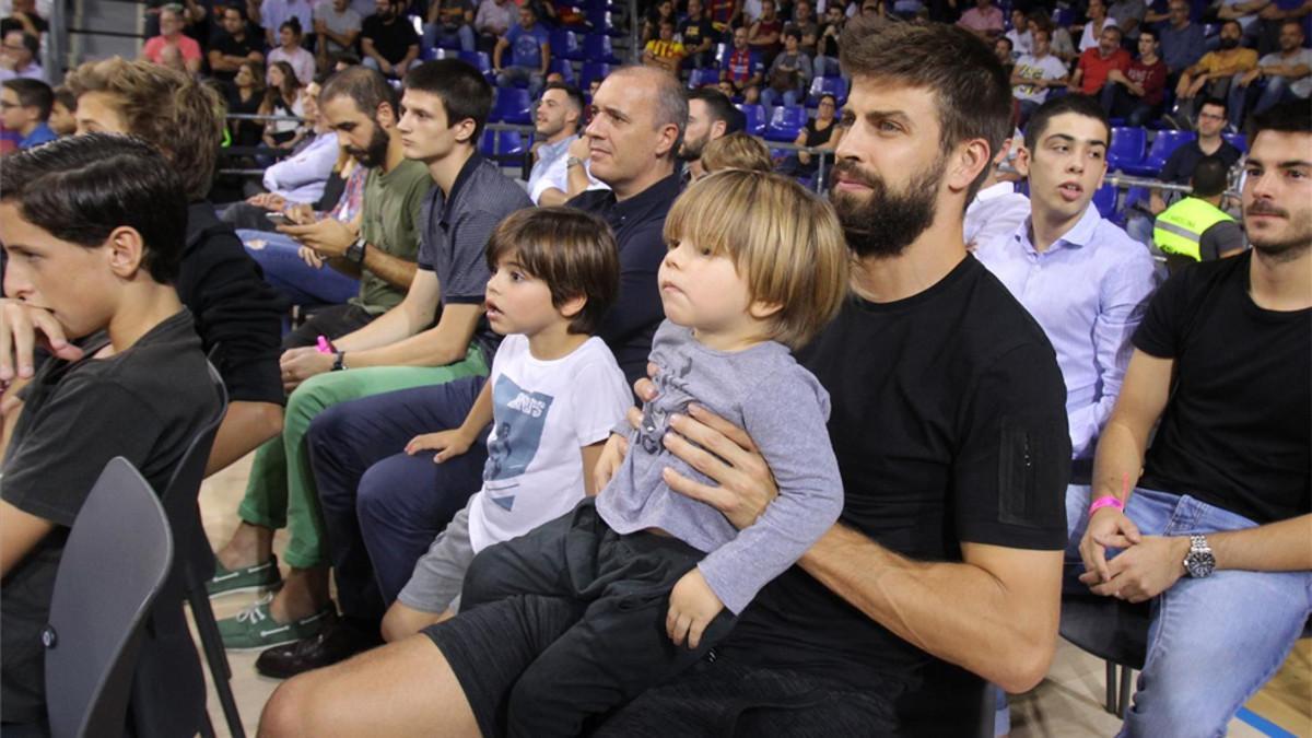 Gerard, con sus dos hijos, siguiendo con atención el partido