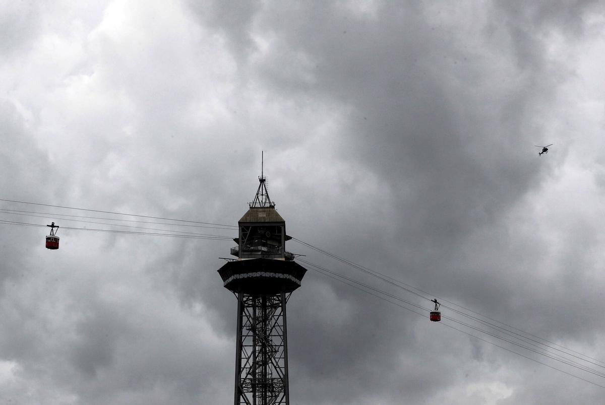 El cielo gris de Barcelona contrasta con las cabinas del teleférico del puerto de la ciudad, en una imagen de archivo.