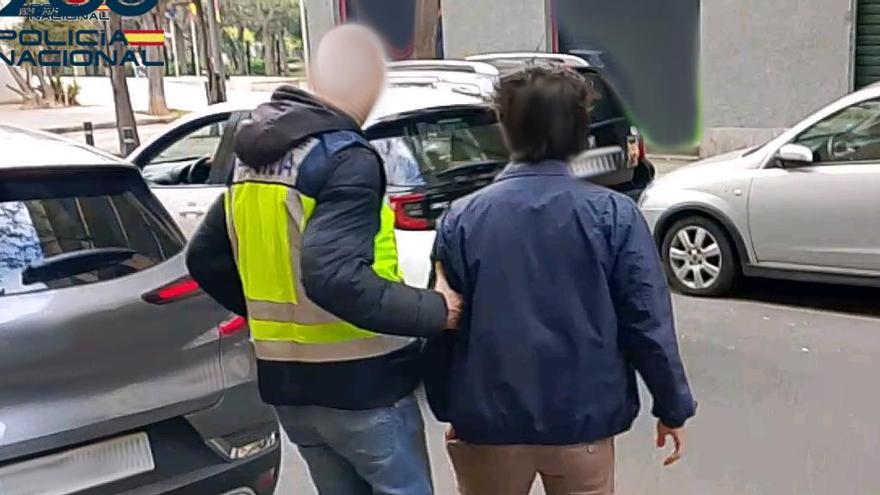 Un policía traslada a uno de los detenidos.