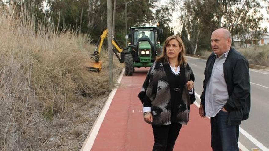 La alcaldesa, con la desbrozadora al fondo.