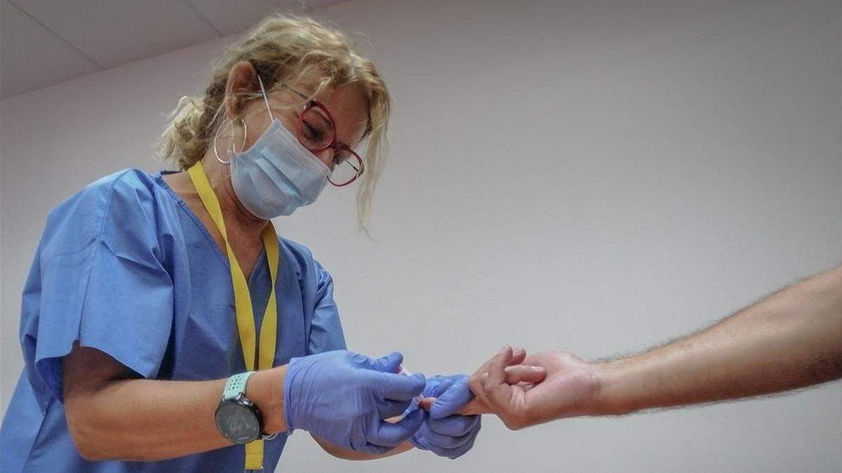 Una sanitaria toma una muestra de sangre para realizar una prueba rápida de covid-19 en el Hospital Militar de Sevilla, el 28 de agosto del 2020