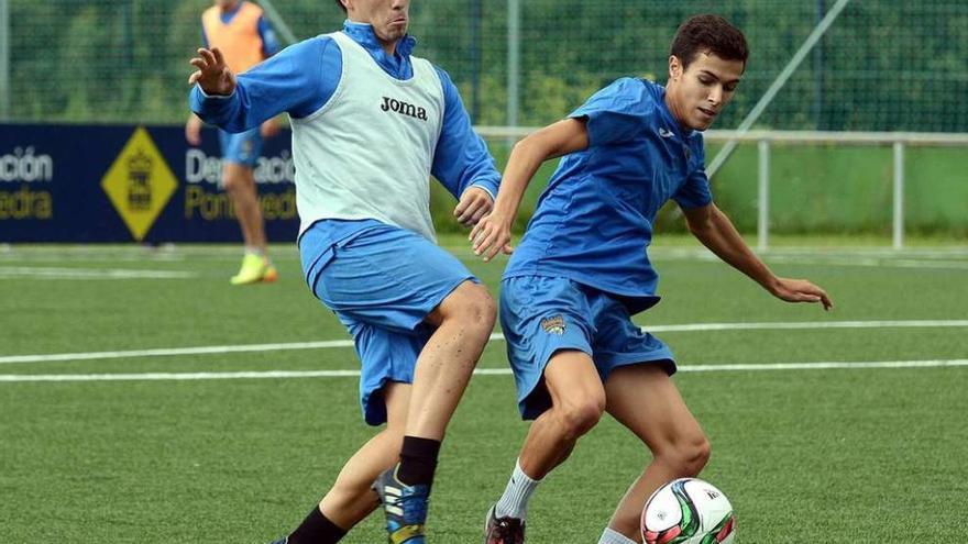 Tomás pugna por un balón con su compañero Miky en un entrenamiento celebrado en la ciudad deportiva de Príncipe Felipe. // Rafa Vázquez