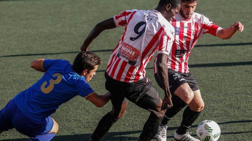 Keko pugna por un balón protegido por dos jugadores del Siero.