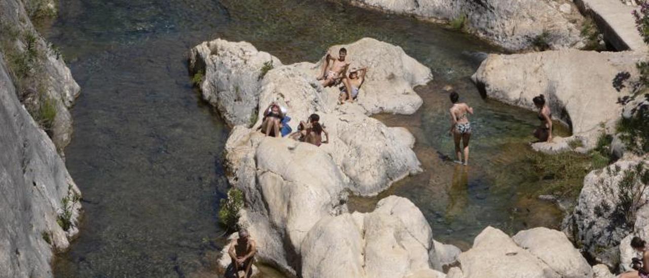 Un grupo de bañistas disfrutar del paraje natural del Pou Clar, en una imagen de archivo. | PERALES IBORRA