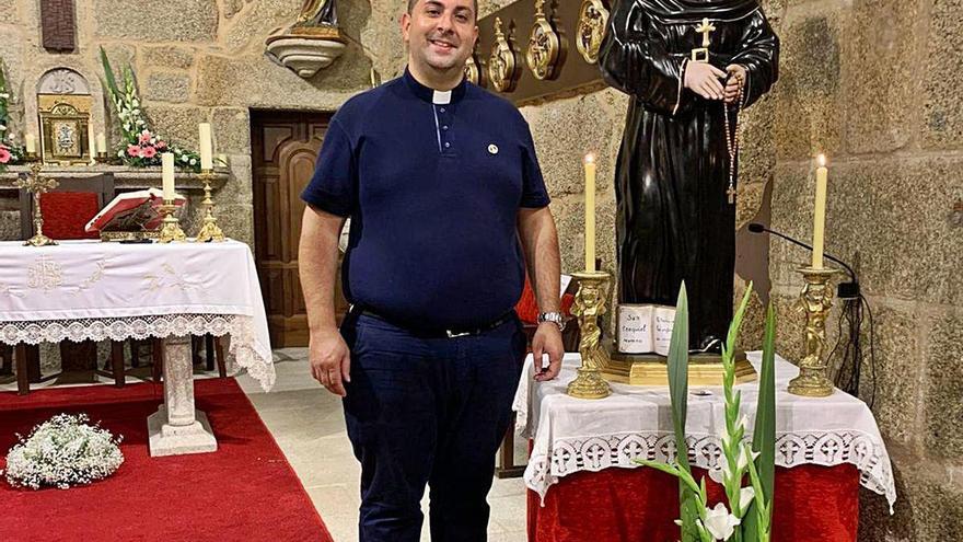 El cura, Juan Ventura Martínez Reboeiras, posa orgulloso junto a la talla de San Ezequiel.